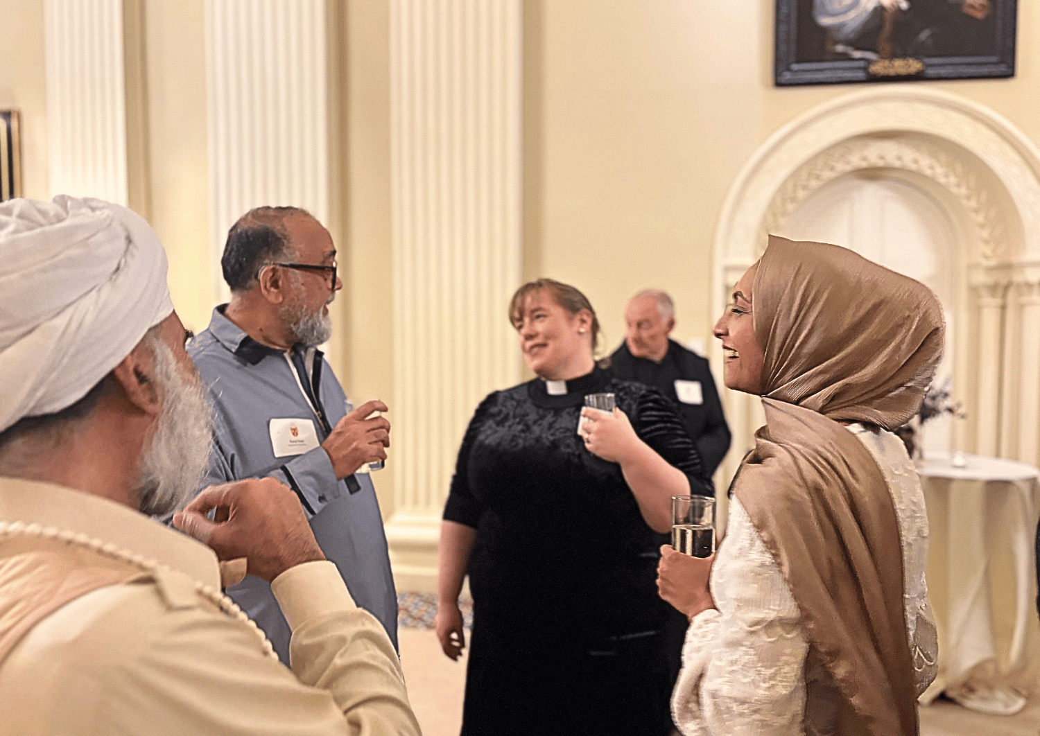 female vicar talking to a Muslim leader, sikh and muslim woman a interfaith event