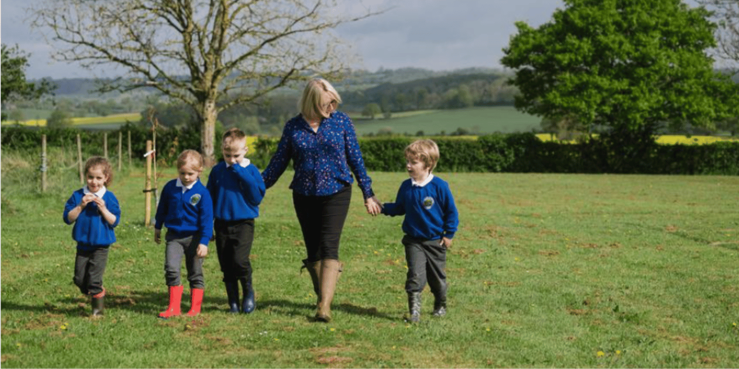 Pupils and teacher at Burley Gate CE Primary school walking across field