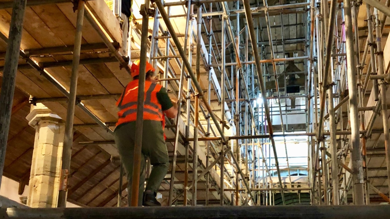 scaffolding inside church with building climbing up ladder