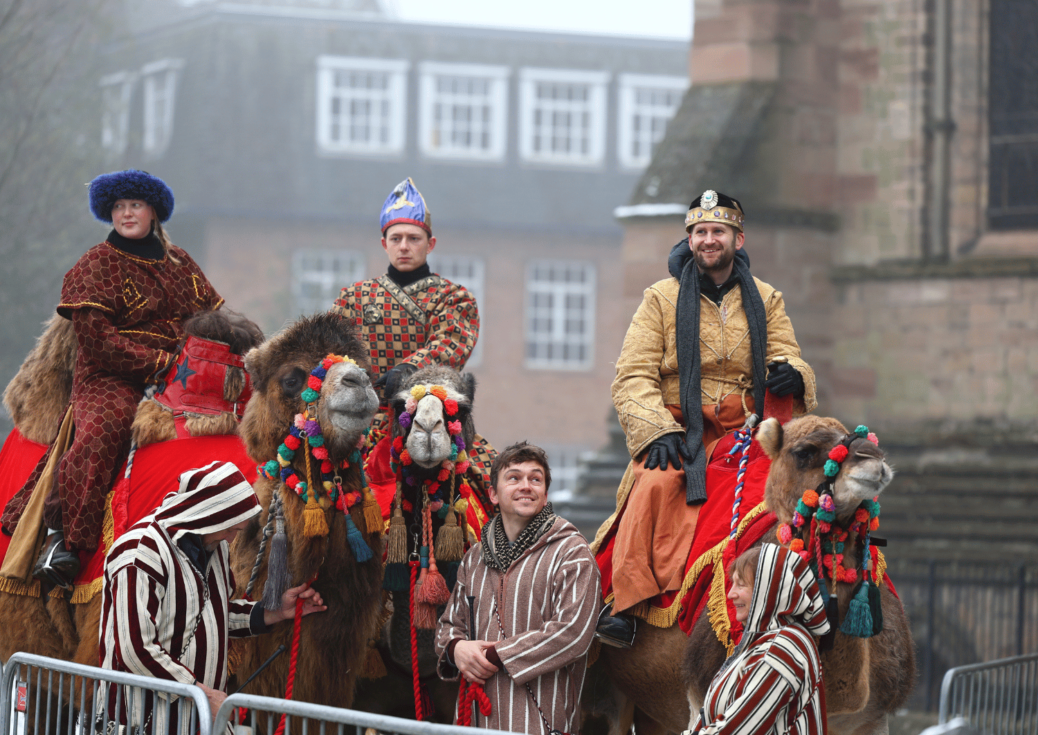 Three kings astride three camels outside hereford cathedral for epiphany service