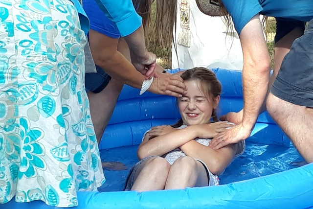 Image of young girl being baptised in pool of water
