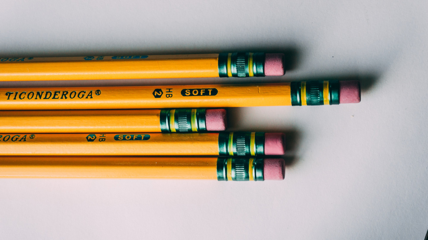 Image of a row of pencils on a sheet of paper