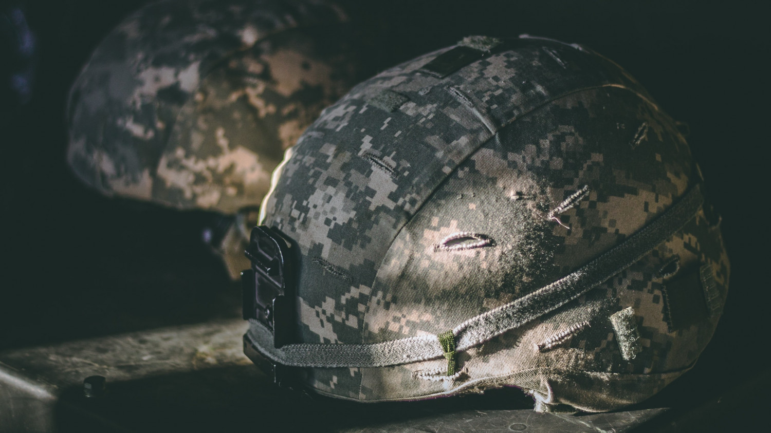 Image of a soldiers helmet on a camp bed