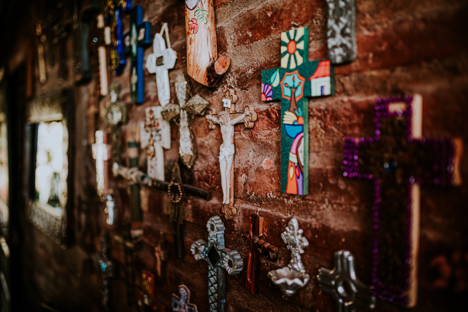 Image of a wall covered in different styles of the cross