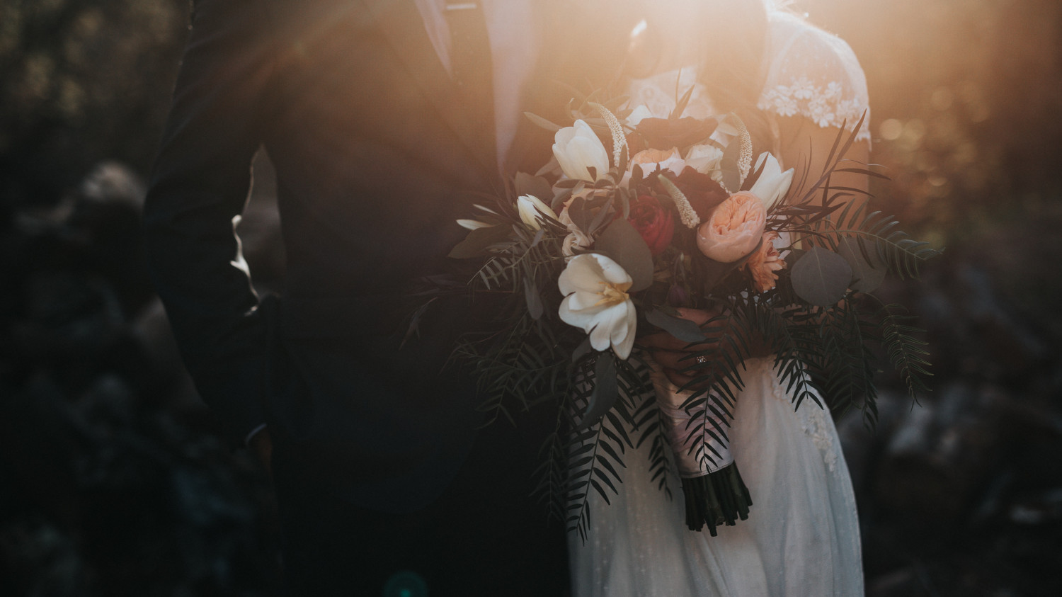 Image of a bride and groom holding a wedding bouquet