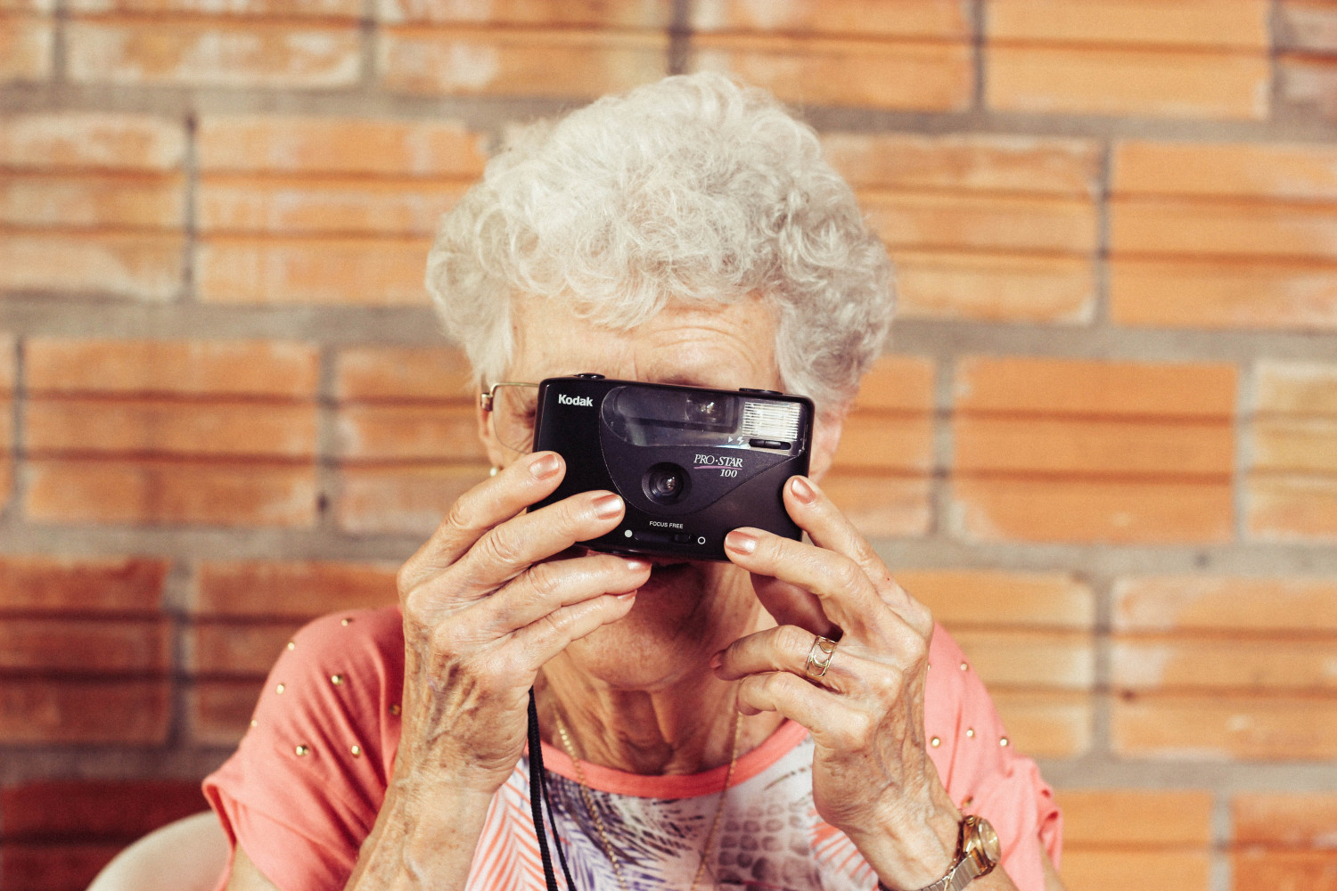 Image of an elderly woman holding up a camera to her face