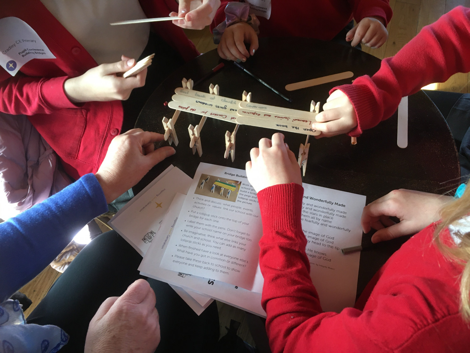 pupils building a wooden bridge labelled with ways of connecting church and school 